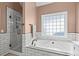 Relaxing bathroom offers a soaking tub, a separate shower, and a large, bright window at 9889 Between The Grns, Villa Rica, GA 30180