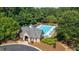 A top-down shot of the community pool and bathhouse, surrounded by lush greenery and trees at 9889 Between The Grns, Villa Rica, GA 30180