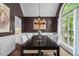 Elegant dining room featuring a dark wood table, white chairs, and a large window with natural light at 9889 Between The Grns, Villa Rica, GA 30180