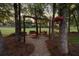 Backyard with a gravel path leading to a fire pit and hanging swings for outdoor enjoyment at 9889 Between The Grns, Villa Rica, GA 30180