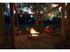 Inviting outdoor firepit area with swing benches under string lights, perfect for relaxation and gatherings at 9889 Between The Grns, Villa Rica, GA 30180