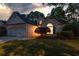 Charming home featuring a manicured lawn and welcoming front entrance with beautiful light spilling from inside at 9889 Between The Grns, Villa Rica, GA 30180