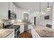 Modern kitchen with white cabinets, granite countertops, stainless steel appliances, and an island with barstool seating at 9889 Between The Grns, Villa Rica, GA 30180