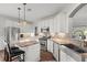 Bright, open kitchen features white cabinets, stainless steel appliances, and a granite island with bar stool seating at 9889 Between The Grns, Villa Rica, GA 30180