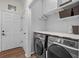 Well-organized laundry room with modern washer and dryer, ample shelving and white cabinets at 9889 Between The Grns, Villa Rica, GA 30180