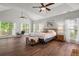 Spacious main bedroom with vaulted ceilings, large windows, and a comfortable bed with ottoman at 9889 Between The Grns, Villa Rica, GA 30180