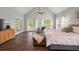 Bright main bedroom with vaulted ceiling, large windows, ceiling fans, and sitting area near the bed at 9889 Between The Grns, Villa Rica, GA 30180