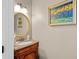 Charming powder room with a marble countertop vanity and decorative mirror at 9889 Between The Grns, Villa Rica, GA 30180