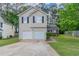 Two-story home featuring a two-car garage, neutral siding, and well-maintained landscaping at 2319 Rambling Way, Lithonia, GA 30058