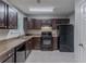 Traditional kitchen with dark cabinets, granite countertops, and black appliances at 2319 Rambling Way, Lithonia, GA 30058