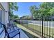 Cozy back patio with seating, a black metal fence and lush greenery in the background at 5299 Noble Village Way, Lilburn, GA 30047
