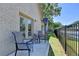 Cozy back patio with seating, a black metal fence and brick exterior of the home at 5299 Noble Village Way, Lilburn, GA 30047
