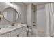 Bathroom features a white vanity, round mirror, and a shower with white subway tile at 5299 Noble Village Way, Lilburn, GA 30047