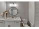 Bathroom features a white vanity, round mirror, and a shower with white subway tile at 5299 Noble Village Way, Lilburn, GA 30047