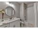 Bathroom features a white vanity, round mirror, and a shower with white subway tile at 5299 Noble Village Way, Lilburn, GA 30047