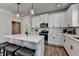 Bright kitchen with white cabinets, subway tile backsplash, stainless steel appliances, and a spacious center island at 5299 Noble Village Way, Lilburn, GA 30047