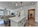 Modern kitchen island featuring white cabinets, quartz countertop, and pendant lighting, with a view of the dining area at 5299 Noble Village Way, Lilburn, GA 30047