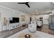 Open-concept living room with modern decor, leading to a dining area and kitchen with stainless steel appliances at 5299 Noble Village Way, Lilburn, GA 30047