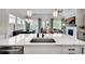 Modern open-concept kitchen featuring a center island, pendant lighting, and views into the dining and living spaces at 208 Idylwilde Way, Canton, GA 30115