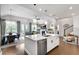Open-concept kitchen with a center island, stainless appliances, and a view into the adjacent living and dining areas at 208 Idylwilde Way, Canton, GA 30115