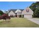 Charming brick home featuring a well-manicured lawn and attached two car garage at 25 Skylar Dr, Covington, GA 30016