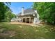 Back exterior elevation with a spacious deck and well-maintained lawn surrounded by mature trees at 2701 Gentry Dr, Douglasville, GA 30135