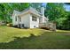 Exterior view of the home showcasing a spacious deck, lush lawn, and mature trees at 2701 Gentry Dr, Douglasville, GA 30135