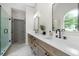 Bathroom with double sinks, stone counters, wood cabinets, and frameless glass shower at 2701 Gentry Dr, Douglasville, GA 30135