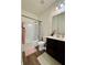 Well-lit bathroom featuring a shower and tub combination and a vanity with dark wood cabinets at 3785 Newbury Place Dr, Loganville, GA 30052