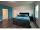 Bedroom with black queen bed, hardwood floors and blue accent wall at 3785 Newbury Place Dr, Loganville, GA 30052