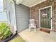 Charming front door with wreath and rocking chair, set on a covered porch at 3785 Newbury Place Dr, Loganville, GA 30052