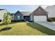 Attractive home with lush green lawn, decorative tree, and convenient driveway access at 3785 Newbury Place Dr, Loganville, GA 30052