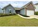 Charming single-story home featuring a well-manicured lawn, brick accents, and a two-car garage at 3785 Newbury Place Dr, Loganville, GA 30052