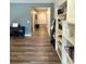 Long hallway with hardwood floors and white built-in storage shelves at 3785 Newbury Place Dr, Loganville, GA 30052