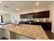 Kitchen with granite countertop on center island, dark cabinets and stainless steel appliances at 3785 Newbury Place Dr, Loganville, GA 30052