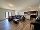 Open concept living room with hardwood floors leading into kitchen with center island at 3785 Newbury Place Dr, Loganville, GA 30052