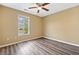 Cozy bedroom featuring hardwood floors, a ceiling fan, and a window at 405 Maple Rdg, White, GA 30184