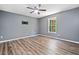 Neutral bedroom featuring wood floors, ceiling fan, window with view, and tv mount at 405 Maple Rdg, White, GA 30184