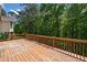 Wood deck overlooks green leafy trees, offering a private and serene outdoor space at 405 Maple Rdg, White, GA 30184