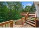Wooden deck with steps leading down to the yard, surrounded by lush green trees and foliage at 405 Maple Rdg, White, GA 30184