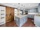 Open kitchen features a large island, custom pantry doors, and modern appliances at 405 Maple Rdg, White, GA 30184