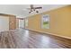 Bright living room with hardwood floors, ceiling fan, and large windows overlooking the neighborhood at 405 Maple Rdg, White, GA 30184