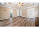 Large primary bedroom features hardwood floors, tray ceiling, fan, and bathroom access at 405 Maple Rdg, White, GA 30184