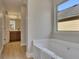 Bright bathroom with a white tub and view to the wood, wooden cabinets in the vanity area at 506 Tallapoosa Trl, Woodstock, GA 30188