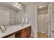 Modern bathroom with wood cabinets, quartz countertops, a wide mirror, and a shower-tub combination at 506 Tallapoosa Trl, Woodstock, GA 30188