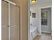 Bright bathroom featuring a shower with glass doors, a bathtub, and a window overlooking the trees at 506 Tallapoosa Trl, Woodstock, GA 30188