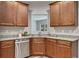 Functional kitchen featuring stainless steel dishwasher, granite counters, and wood cabinets at 506 Tallapoosa Trl, Woodstock, GA 30188