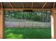 View through a backyard pergola, featuring a picket fence and a lush green landscape at 506 Tallapoosa Trl, Woodstock, GA 30188