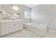 Elegant bathroom featuring a soaking tub, and a white marble tile surround at 6375 Haystack Ct, Cumming, GA 30040