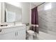 Bright bathroom featuring a white vanity, a shower with marble-patterned tile, and modern fixtures at 6375 Haystack Ct, Cumming, GA 30040